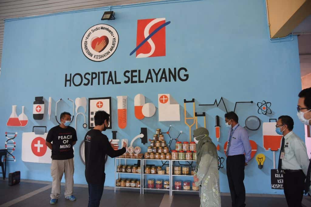 Dr Sakinah Binti Alwi, Director, Selayang Hospital (third from left) and Subramaniam Sandracasen, Deputy Managing Director, Hospital Selayang (fourth from left) taking a look at the cupboard filled with traditional and healthy Raya treats, which is part of the Gerobok Raya initiative