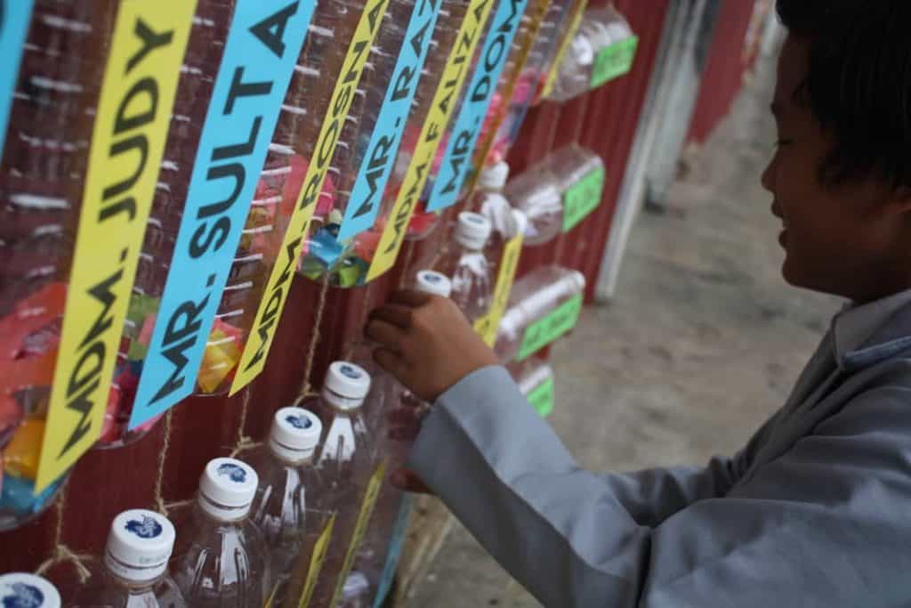 Mr. Leo of Sekolah Kebangsaan Ba Kelalan repurposes used plastic bottles into mailboxes for the school’s “English Corner”.